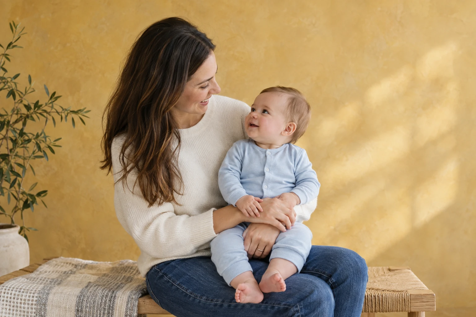 Woman smiling at an infant seated on her lap.